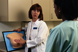 Fournisseur de soins de santé expliquant l'auto-examen des seins.
